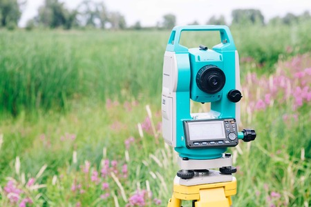 blue surveying  equipment total station on a background of meadowの写真素材