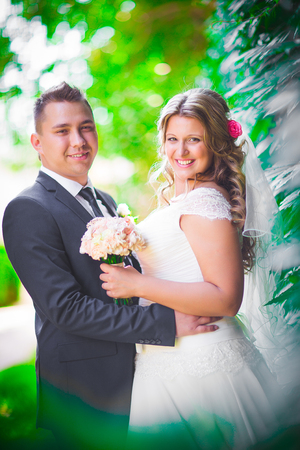 Happy couple  bride and groom embracing they stand on background nature close-upの写真素材