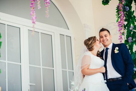 Bride and  groom posing in a hotel room on background windowsの写真素材