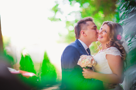 Happy couple  bride and groom embracing they stand on background nature close-upの写真素材