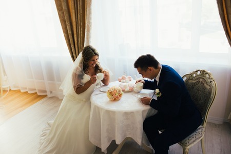 Bride and groom posing  in a hotel roomの写真素材