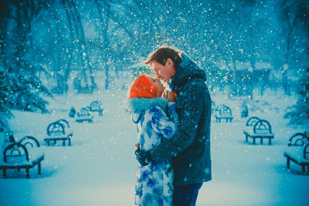 beautiful young couple kiss on snow park backgroundの写真素材