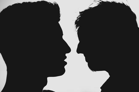 Silhouette of two men  about to kissの写真素材