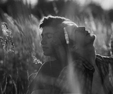 Two young men sited on  the fieldの写真素材
