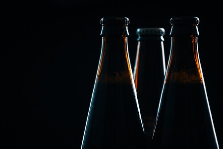 three bottle of dark  beer on a blurred backgroundの写真素材
