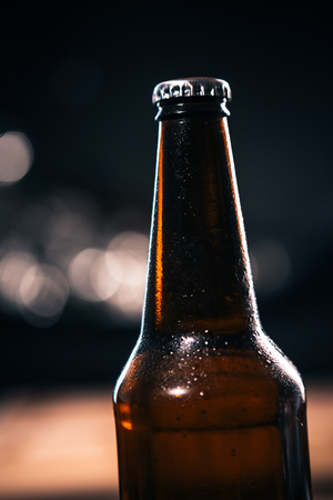 dark bottle of  dark beer on a blurred backgroundの写真素材