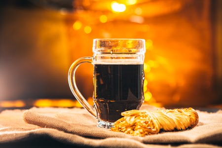 A glass of fresh  dark beer with smoked cheese  on sackingの写真素材