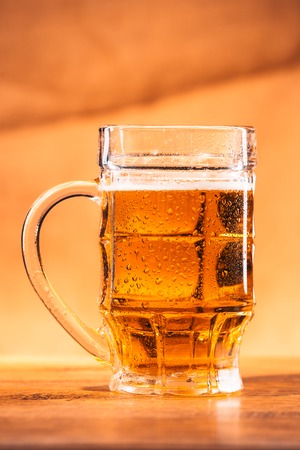 glass bright beer mug on a blurred  backgroundの写真素材