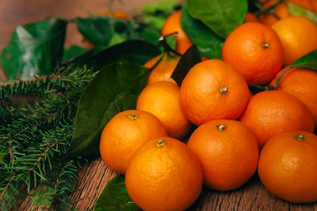 many fresh mandarins and branches  of a Christmas tree on a wooden backgroundの写真素材