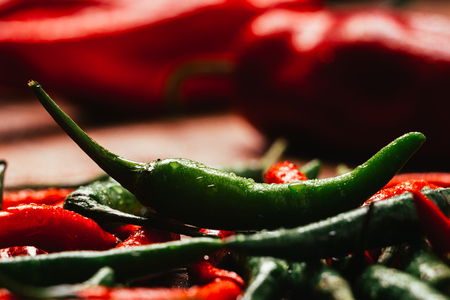 red and green chili peppers  close up on wooden backgroundの写真素材