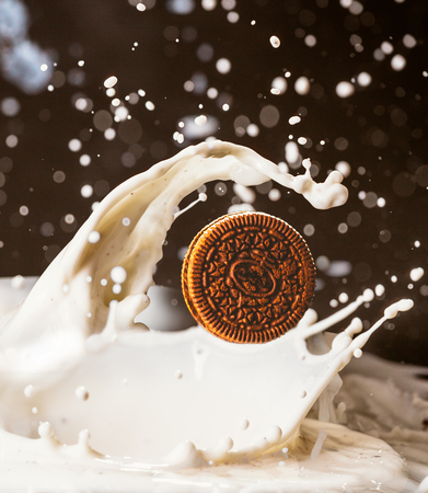 cookies and milk splash on dark  backgroundの写真素材
