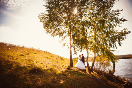 young bride and groom on the  background of the lakeの写真素材