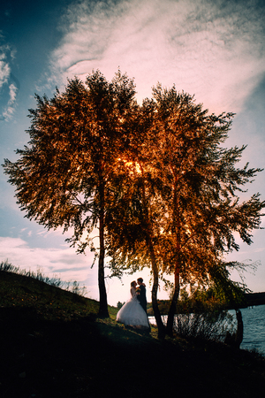 young bride and groom on the  background of the lakeの写真素材