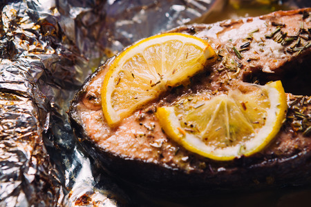 fish steak baked with lemon and herbs  in foilの写真素材