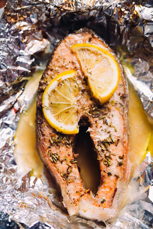 fish steak baked with lemon and herbs  in foilの写真素材