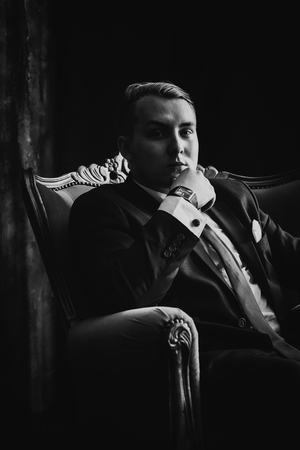 Black white  photography portrait of man in black classic  suit on a dark background.の写真素材