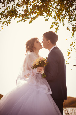 young bride and groom on the  background of the lakeの写真素材