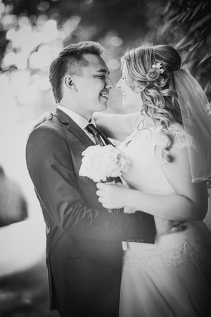 Black white  photography happy couple  bride and groom embracing they stand on background nature close-upの写真素材