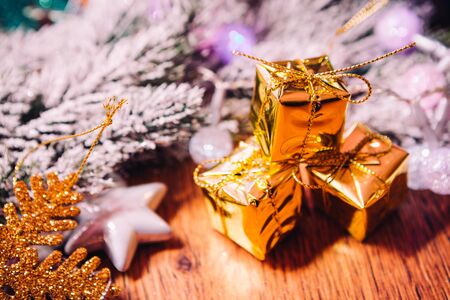 Spruce branches in the  snow gold and white christmas decoration on wooden backgroundの写真素材