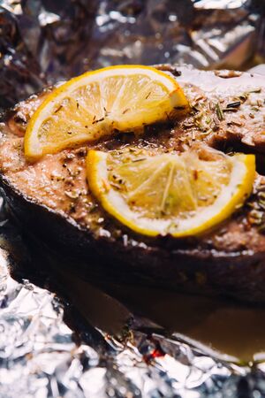 fish steak baked with lemon and herbs  in foilの写真素材