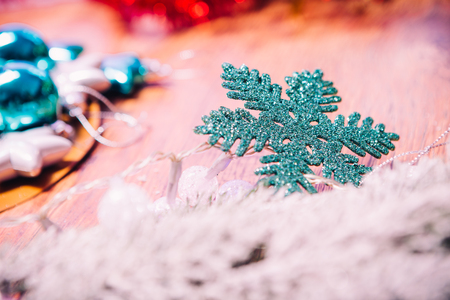 Spruce branches in the snow,  and blue snowflake wooden backgroundの写真素材