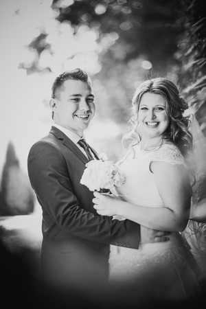 Black white  photography happy couple  bride and groom embracing they stand on background nature close-upの写真素材