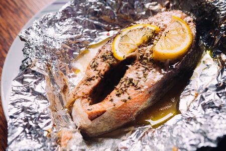 fish steak baked with lemon and herbs  in foilの写真素材