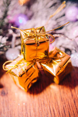 Spruce branches in the  snow gold and white christmas decoration on wooden backgroundの写真素材