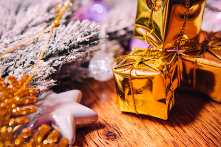 Spruce branches in the  snow gold and white christmas decoration on wooden backgroundの写真素材
