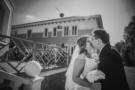 Black white  photography bride and groom embracing they stand on background beautiful architecture of the city full lengthの写真素材