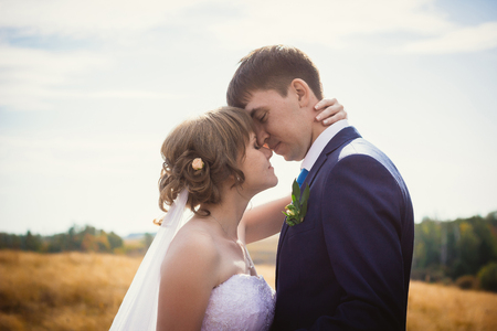 young bride and groom on  the background of the fieldの写真素材