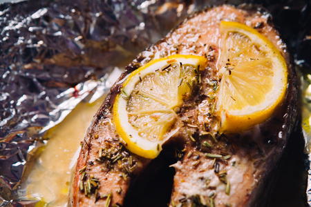 fish steak baked with lemon and herbs  in foilの写真素材