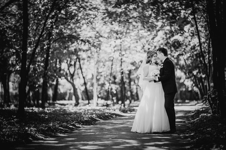Black white photography happy couple  bride and groom embracing they stand in a forest full lengthの写真素材
