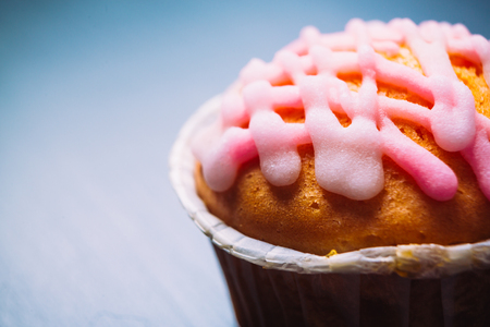 cupcake with pink frosting on  a wooden backgroundの写真素材