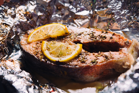 fish steak baked with lemon and herbs  in foilの写真素材