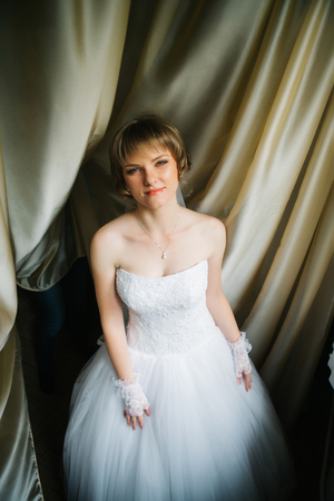 portrait of a beautiful  young bride on the background of beautiful fabricsの写真素材