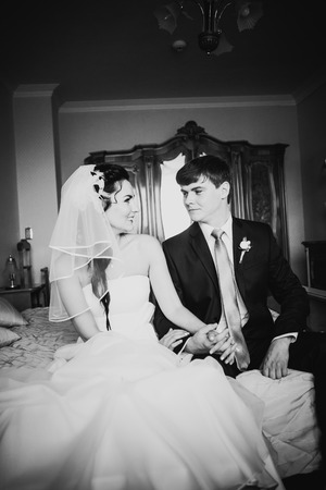 Black  white photography beautiful young couple sitting on the bedの写真素材