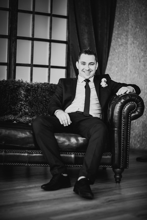 Black white photography  elegance groom is posing on the  background roomの写真素材