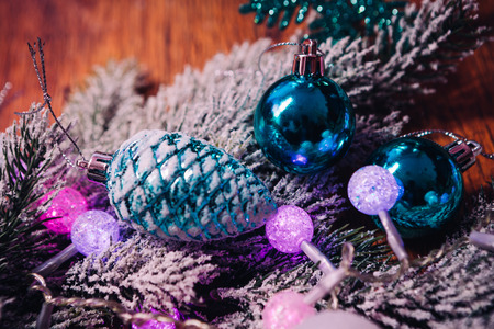 Spruce branches in the  snow violet blue and white christmas balls on dark wooden backgroundの写真素材