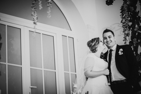 Black white photography bride and  groom posing in a hotel room on background windowsの写真素材