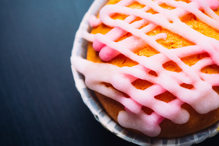 cupcake with pink frosting on  a wooden backgroundの写真素材