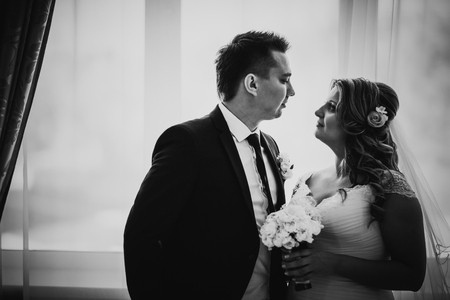 Black white photography bride and groom posing in a  hotel room on background windowsの写真素材