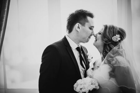 Black white photography  bride and groom posing in a hotel room on background windowsの写真素材