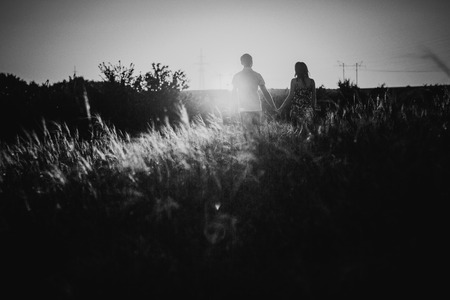 Black white photography romantic couple standing  and kissing on background summer meadow sunsetの写真素材