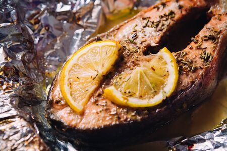 fish steak baked with lemon and herbs  in foilの写真素材