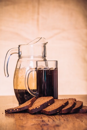 Russian brew in mug jug  and loaf of rye flour on wooden backgroundの写真素材