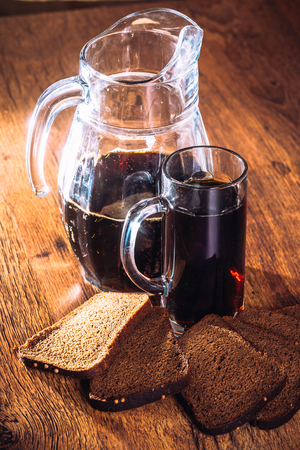 Russian brew in mug jug  and loaf of rye flour on wooden backgroundの写真素材