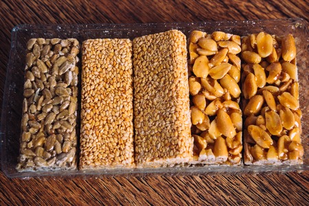 Kozinaki of sunflower, sesame, peanut on  a wooden backgroundの写真素材