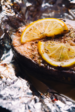 fish steak baked with lemon and herbs  in foilの写真素材