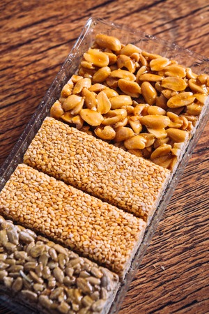 Kozinaki of sunflower, sesame, peanut on  a wooden backgroundの写真素材